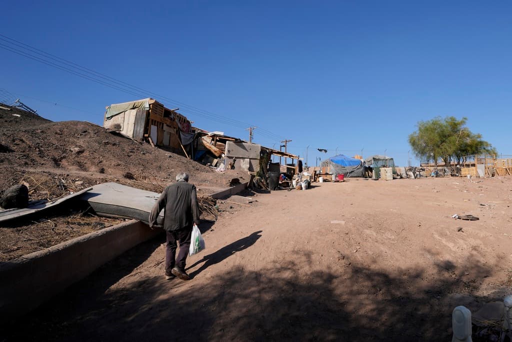 Un hombre sin hogar lleva una bolsa con bebidas que le dio Maribel Padilla, de la Brown Bag Coalition.