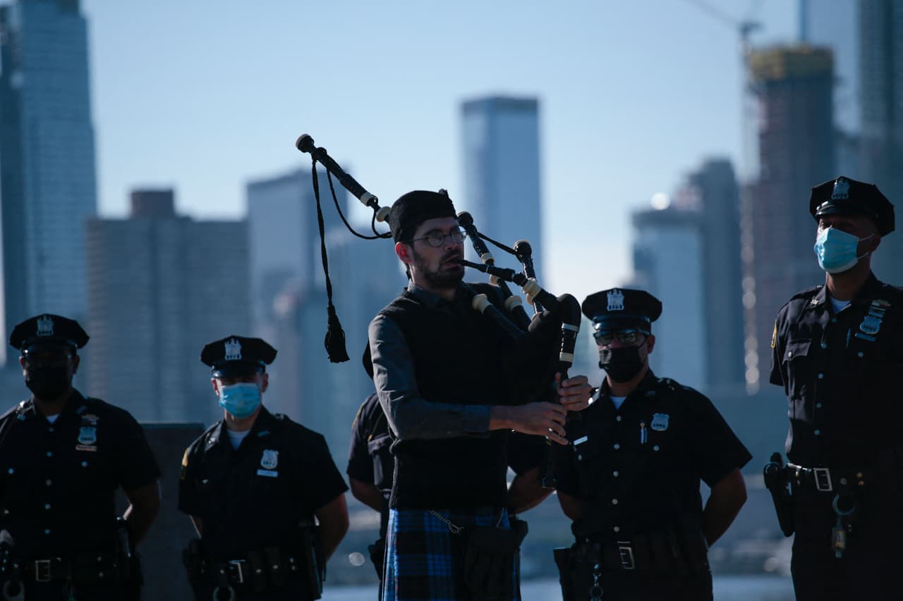 Un gaitero toca su instrumento durante la ceremonia de conmemoración en Weehawken, Nueva Jersey. Al fondo el perfil del Bajo Manhattan, zona que quedó inutilizada por semanas después de los atentados del 11 de septiembre de 2001.