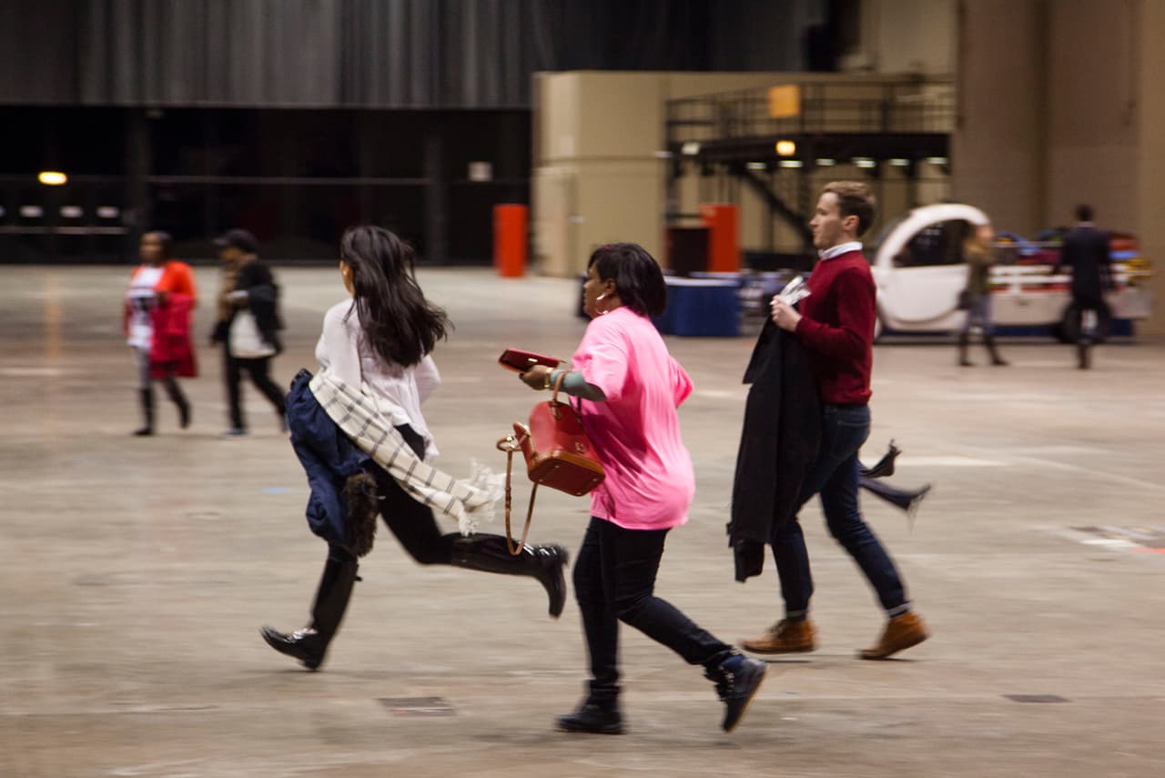 Algunas personas corren a tomar un puesto dentro del centro de convenciones McCormick.