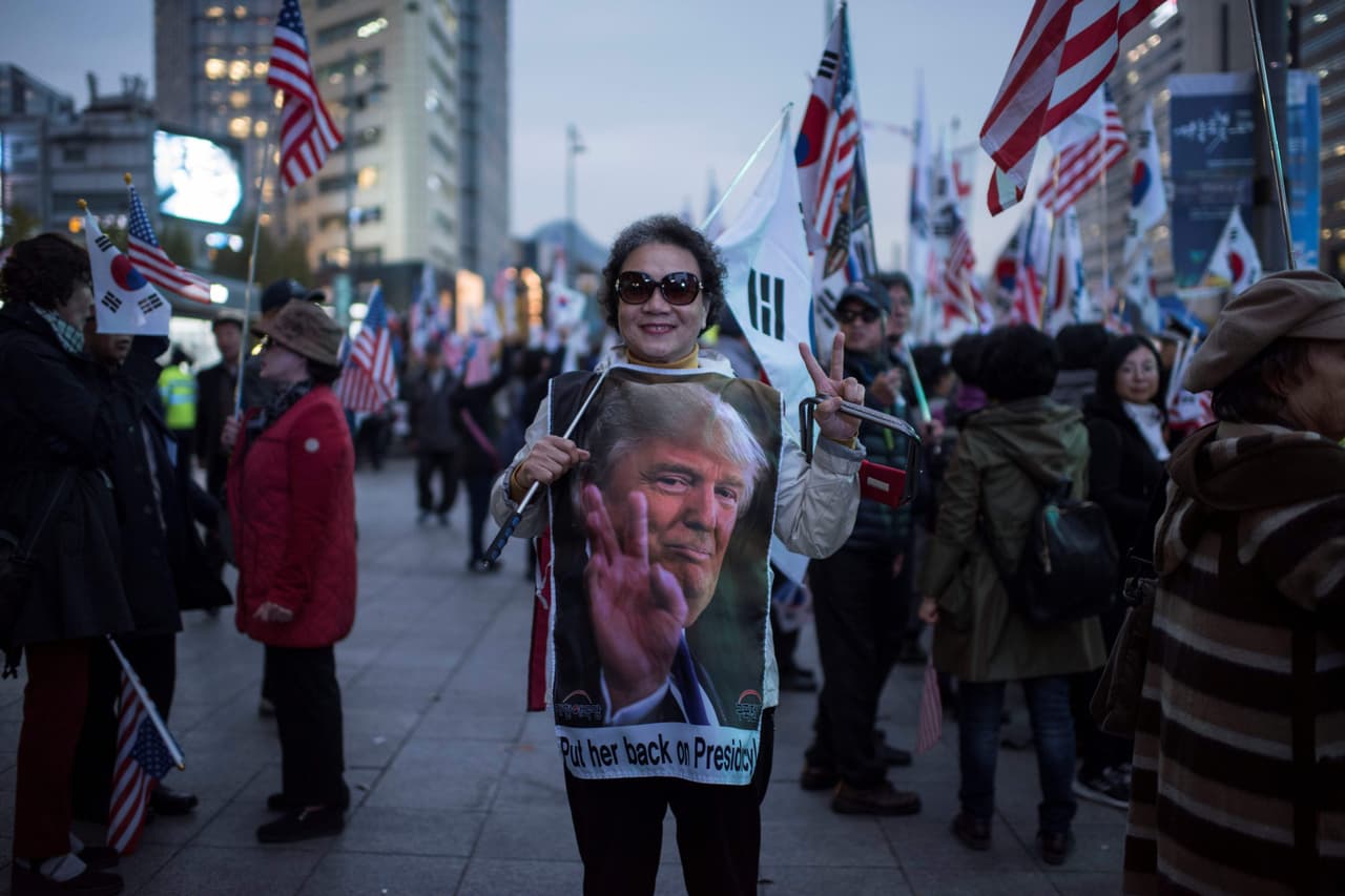 Una partidaria de la expresidenta surcoreana Park Geun-Hye, recién destituida de su cargo, viste una camiseta de Donald Trump mientras espera que el convoy del presidente estadounidense por el área de Gwanghwamun, en el centro de Seúl.