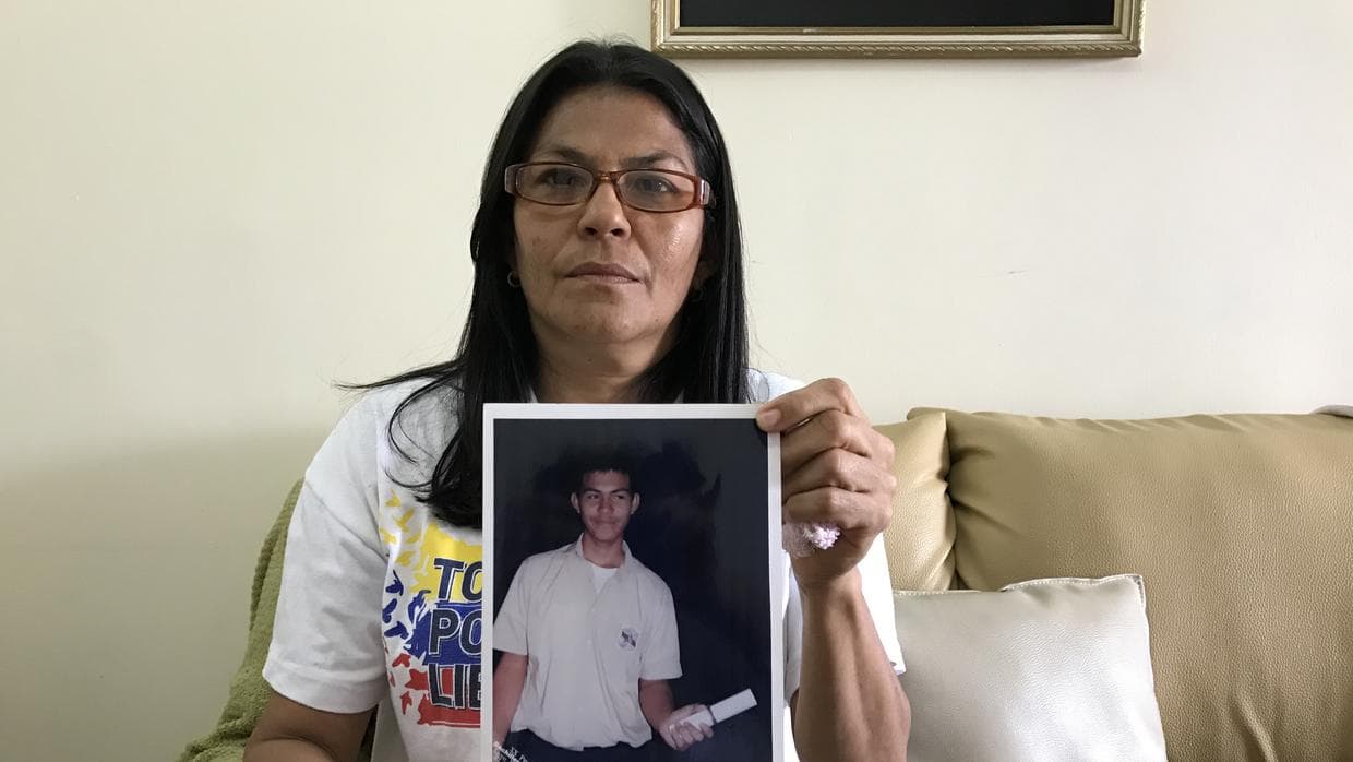Alis Flores, the mother of student Carlos Ramirez, shows a photo of her son's graduation.