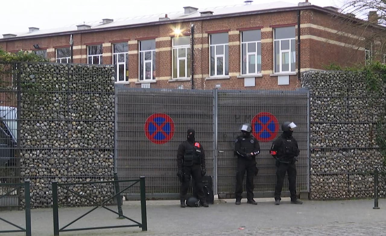 Oficiales de policía resguardaron la entrada de una escuela en Molenbeek, pues algunos alumnos se encontraban dentro durante el operativo de este viernes. (Foto: AP)
