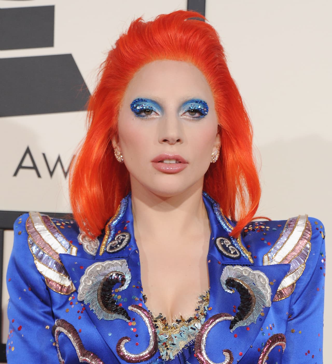 Lady Gaga / El homenaje de la cantante a Ziggy Stardust fue tan legendaria como se pudo predecir. Gaga tiñó su pelo de naranja y ocultó sus cejas para los dos atuendos que vistió. Para el primero, llevó los párpados azules con pequeños apliques de fantasía y ,para el segundo, el icónico maquillaje en naranja –del párpado hacia afuera y sobre los pómulos– se fusionó con las proyecciones que se hicieron sobre el rostro de la cantante.