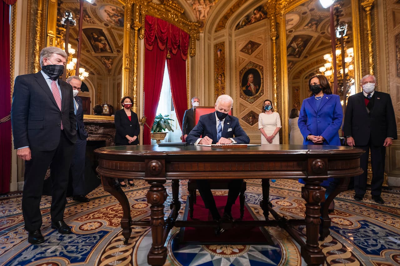 El presidente de los Estados Unidos, Joe Biden, firma tres documentos que incluyen una declaración de toma de posesión, nominaciones al gabinete y nominaciones al subgabinete, mientras la vicepresidenta de los Estados Unidos, Kamala Harris, observa en la Sala de los Presidentes del Capitolio, después de la ceremonia de inauguración presidencial de este 20 de enero de 2021.