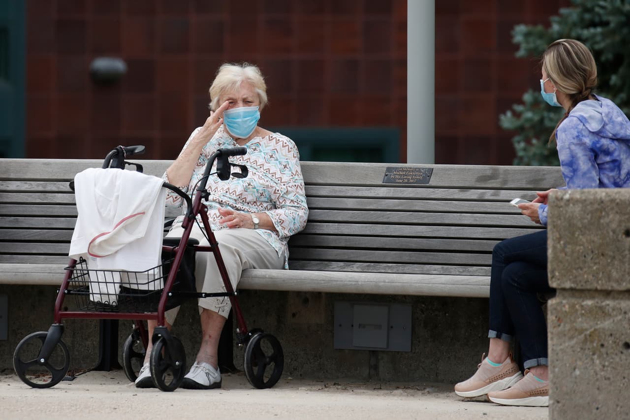 Un residente de un asilo de ancianos conversa, manteniendo la distancia, en Revere, Massachusetts.
