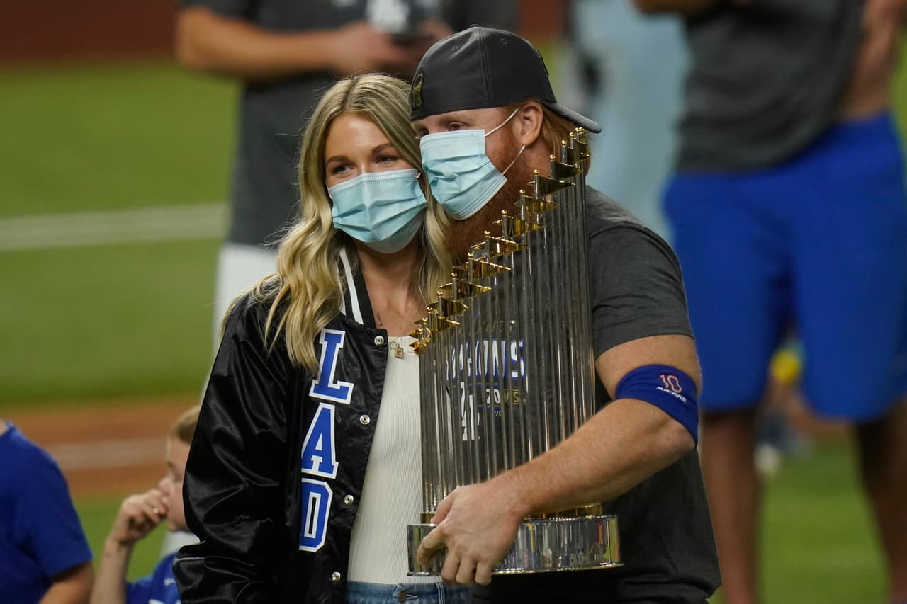 Justin Turner, su esposa y el trofeo del campeonato de Grandes Ligas.