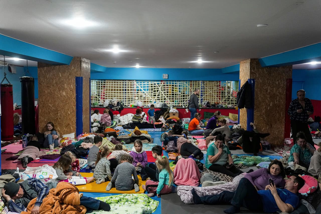 Familias protegidas de los ataques de cohetes y bombas en el sótano de un centro deportivo de Mariupol, al sureste de Ucrania. Esta ciudad ha sido fuertemente atacada por las fuerzas rusas durante la invasión. 27 de febrero.
<br>