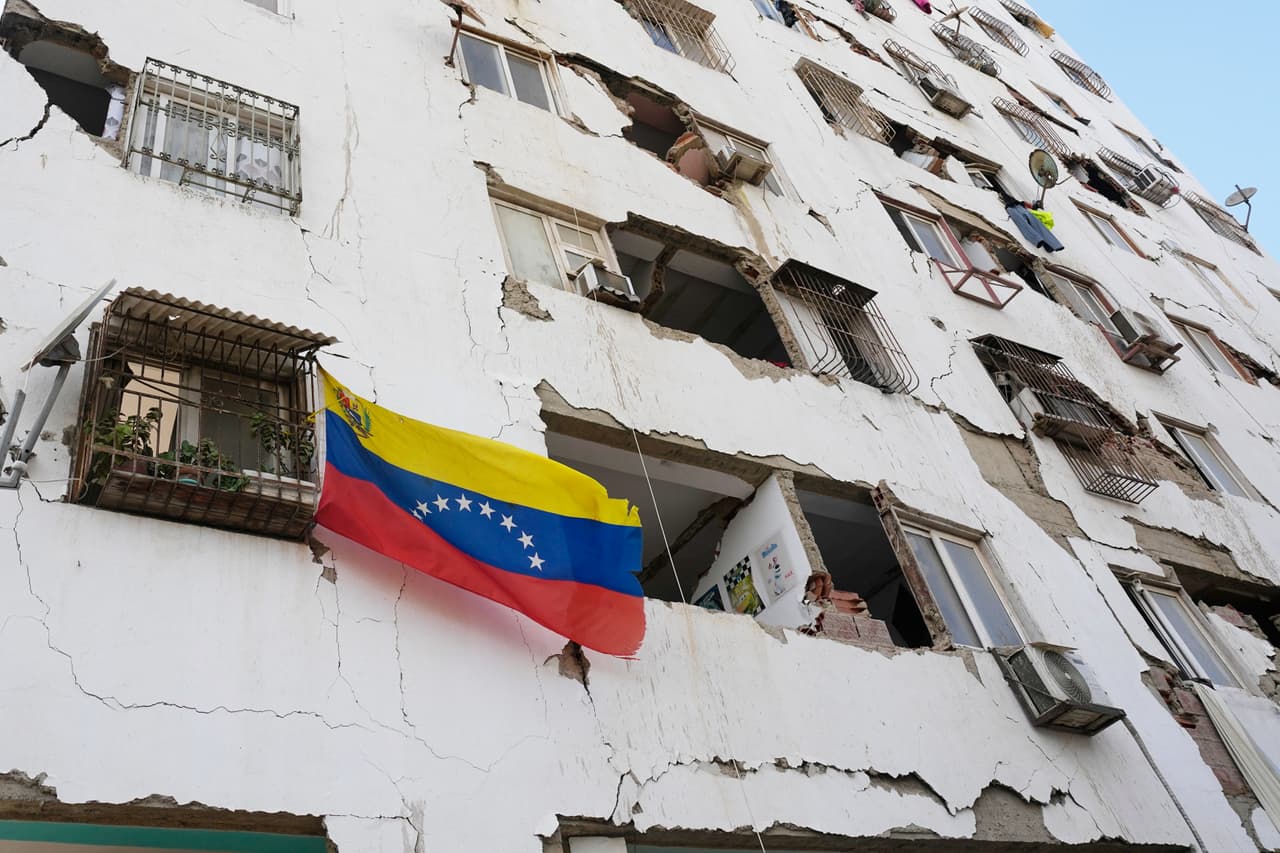 Una bandera venezolana se sostiene en las ruinas de un edificio de Caitia La Mar.