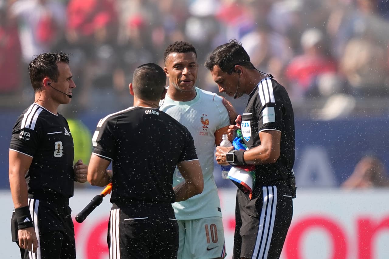 Kylian Mbappé habla, después de haber cobrado su penalti, con el árbitro Facundo Tello.