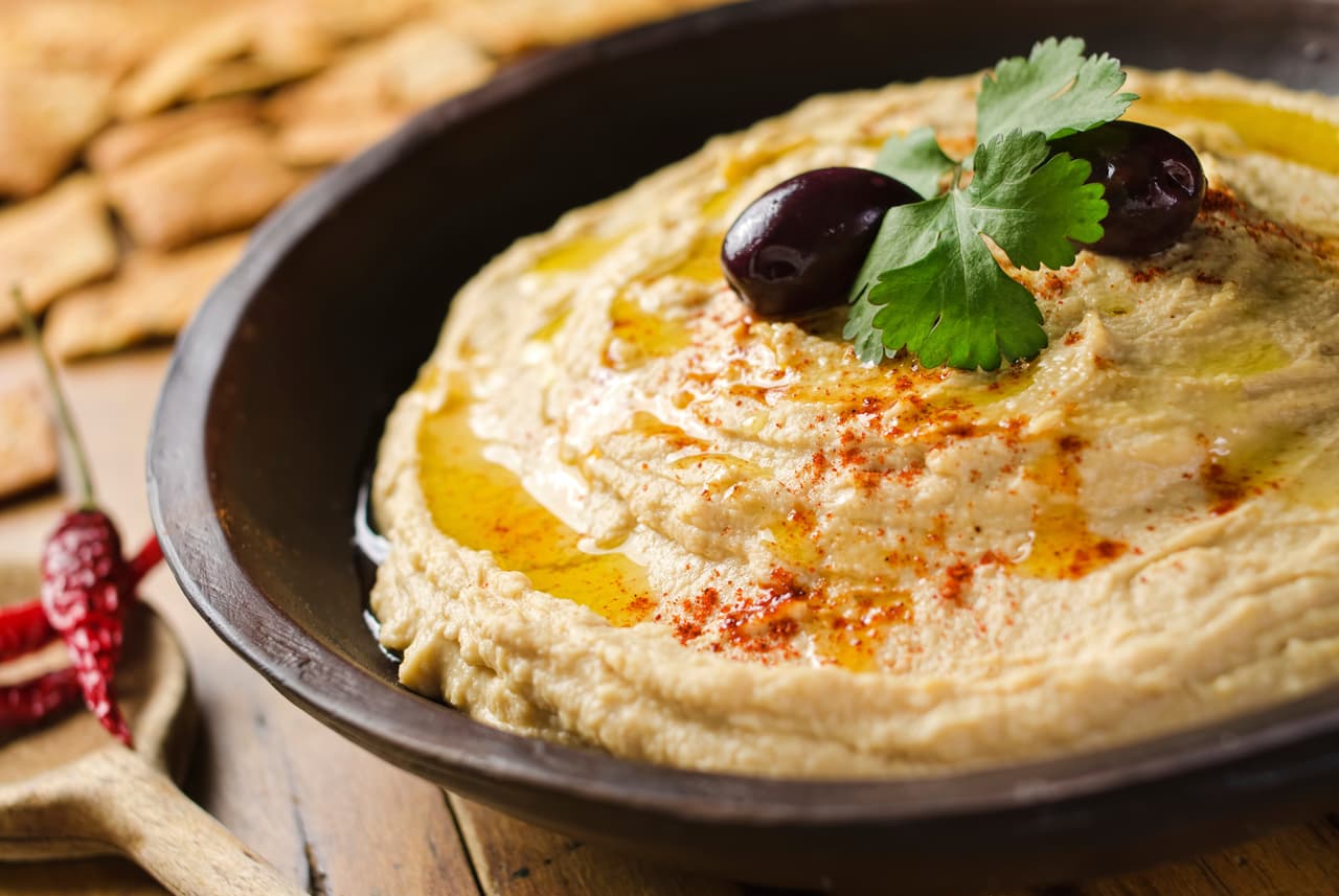 Hummus. El hummus es una crema de puré de garbanzos cocidos con zumo de limón, que incluye pasta de tahina y aceite de oliva.