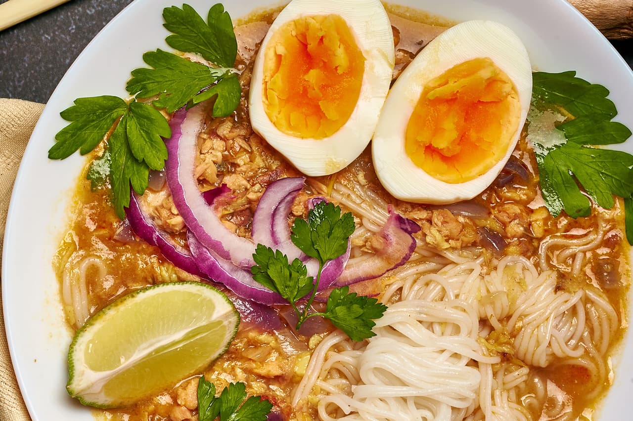 <b>Mohinga</b>
<br>
<br>
<b>Origen: Myanmar</b>
<br>
<br>Esta popular sopa se sirve generalmente como desayuno y en gran parte de Myanmar los vendedores ambulantes la ofrecen enormes tazones humeantes. El alma de esta plato de pescado y fideos es su caldo aromático, que se cuece a fuego lento con hierbas y se espesa con polvo de arroz tostado. Cada región tiene su propia versión de la receta clásica.
<br>