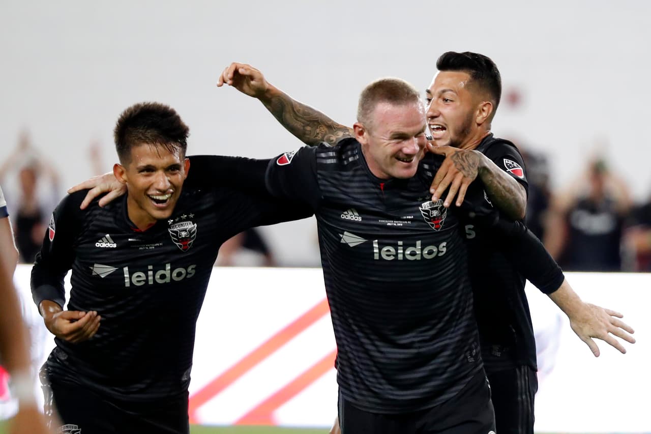 Wayne Rooney celebró la victoria en su debut en MLS con Yamil Asad y Luciano Acosta.