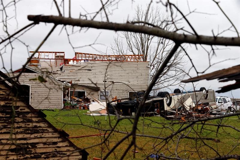 Una caravana permanece volcada delante de una casa fuertemente dañada tras la cadena de tornados que han tenido lugar en Garland, Texas.