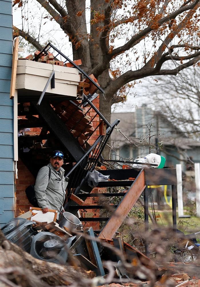 Un hombre recoge sus pertenencias en una casa destrozada por el tornado en Garland.