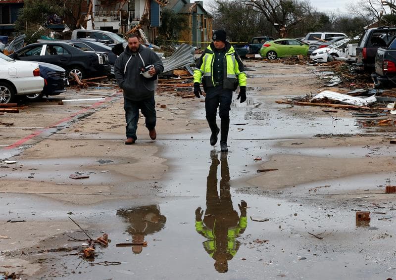 El señor David Ruiz es escoltado por un oficial de policía de Garland, mientras se dirige a su vehículo en busca de algunos objetos personales.