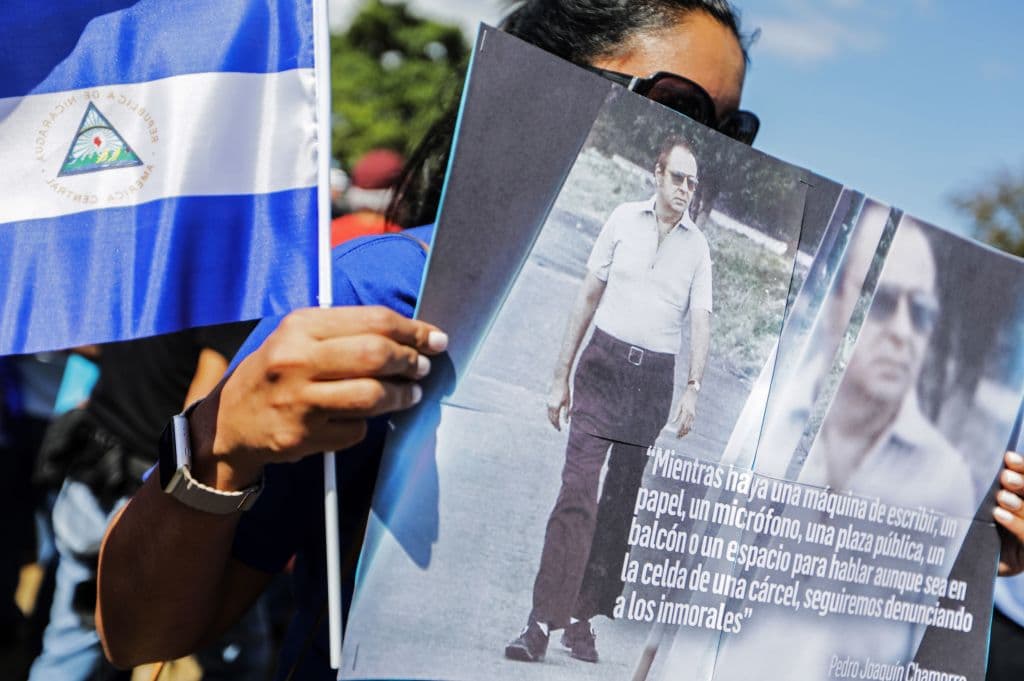 Una mujer muestra una pancarta con la foto de Pedro Joaquín Chamorro durante la conmemoración del aniversario 42 de su asesinato.