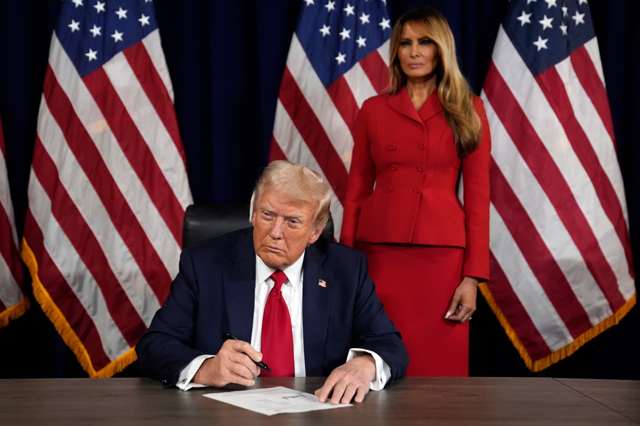 Mientras Melania Trump observa, el candidato presidencial republicano y expresidente Donald Trump firma los documentos para aceptar oficialmente la nominación durante el último día de la Convención Nacional Republicana.
