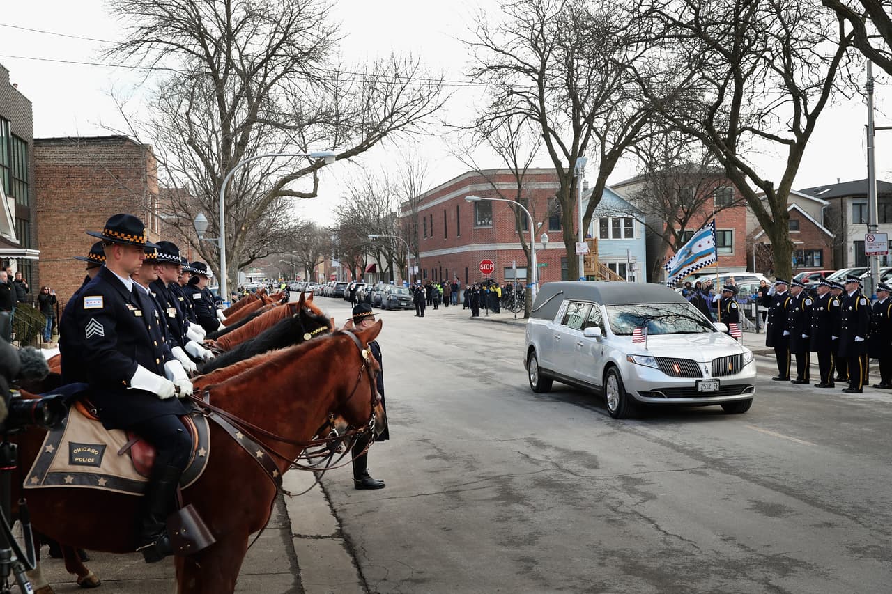 El carro fúnebre de color plata que contenía el cuerpo de Bauer llegó a la iglesia donde se realizaría el velorio, justo antes de las 12:30 pm. Cuatro oficiales de a pie le fueron abriendo paso.