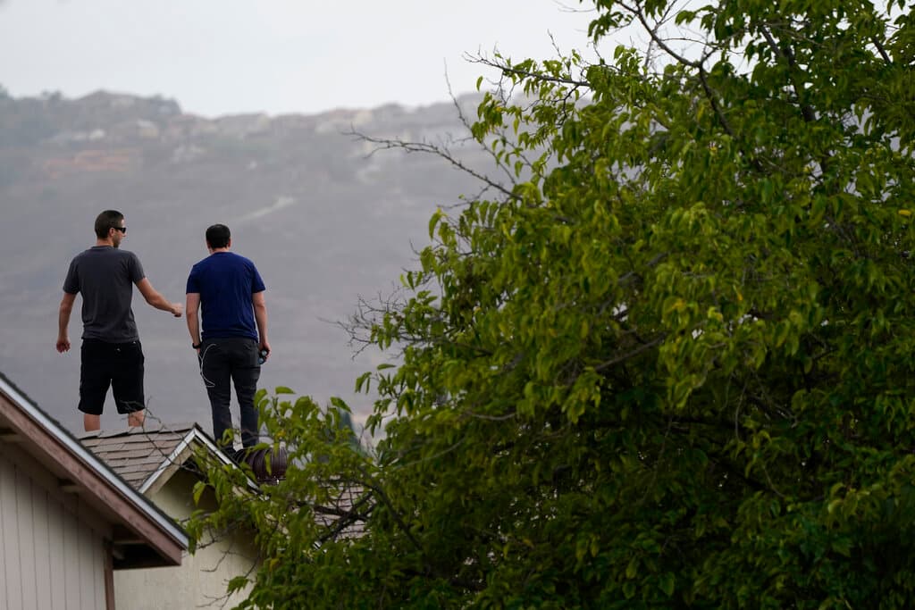 Otras personas observaron los daños del accidente desde los techos de sus casas.