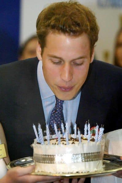 El príncipe William soplando las velitas de su pastel número 21.