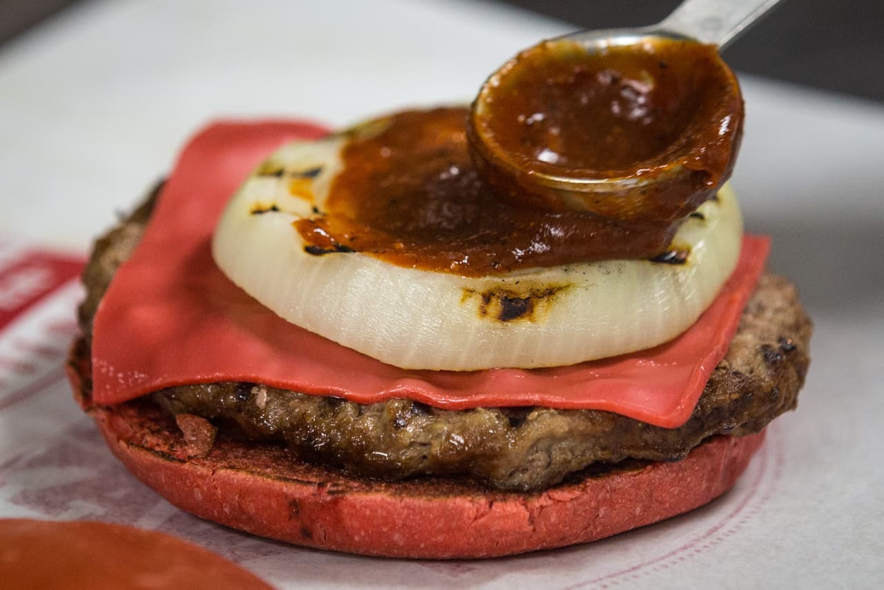 Para que adquieran el tono rojizo, el pan y el queso son bañados en jitomate.