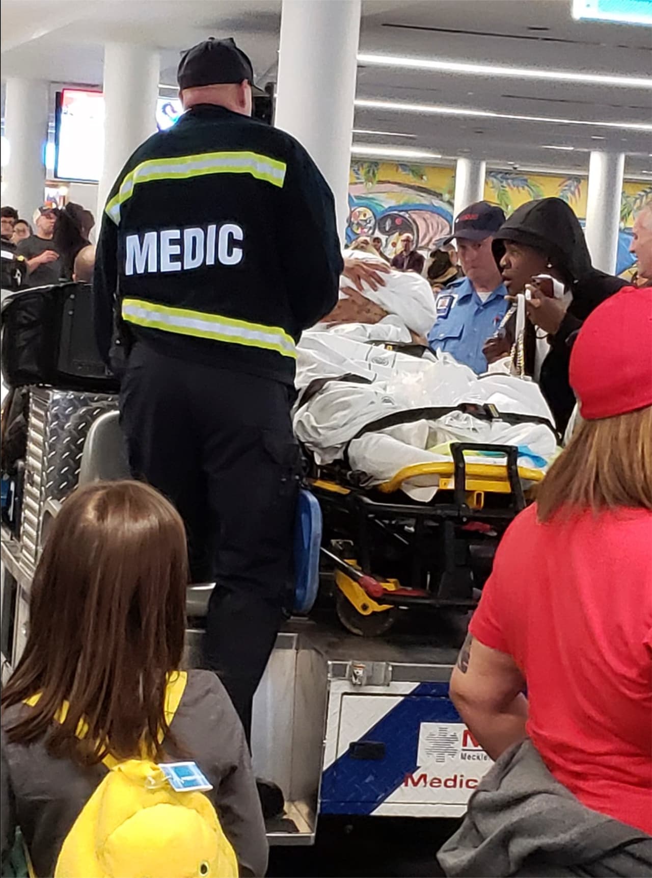 Tras el aterrizaje, paramédicos y personal de emergencia asisten a la mujer y la pequeña, que nació en el avión.