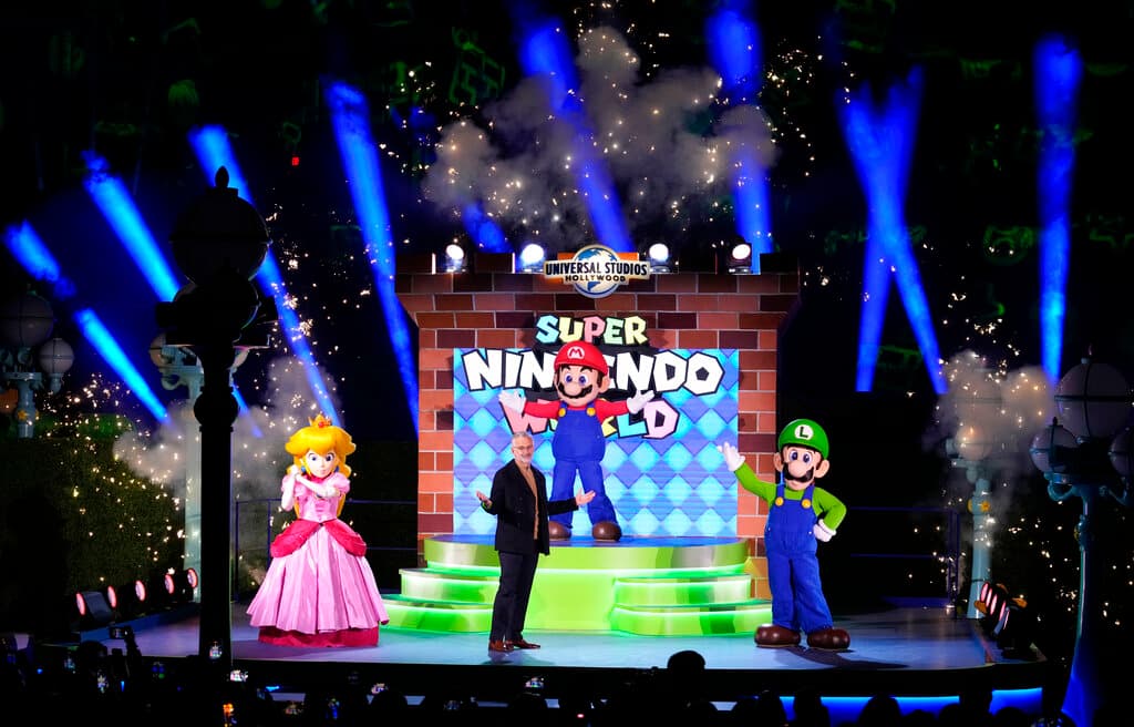 Mark Woodbury, presidente y director ejecutivo de Universal Parks & Resorts, acompañado en el escenario por Princess Peach, Mario y Luigi.
