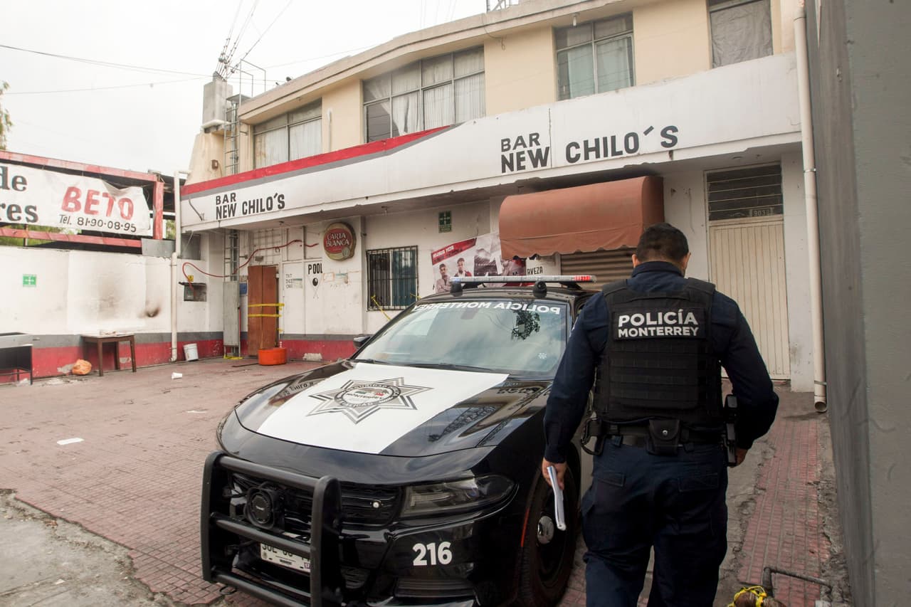Un policía de Monterrey vigila un bar donde personas fueron asesinadas al amanecer en un ataque simultáneo en Monterrey, Nuevo León, México