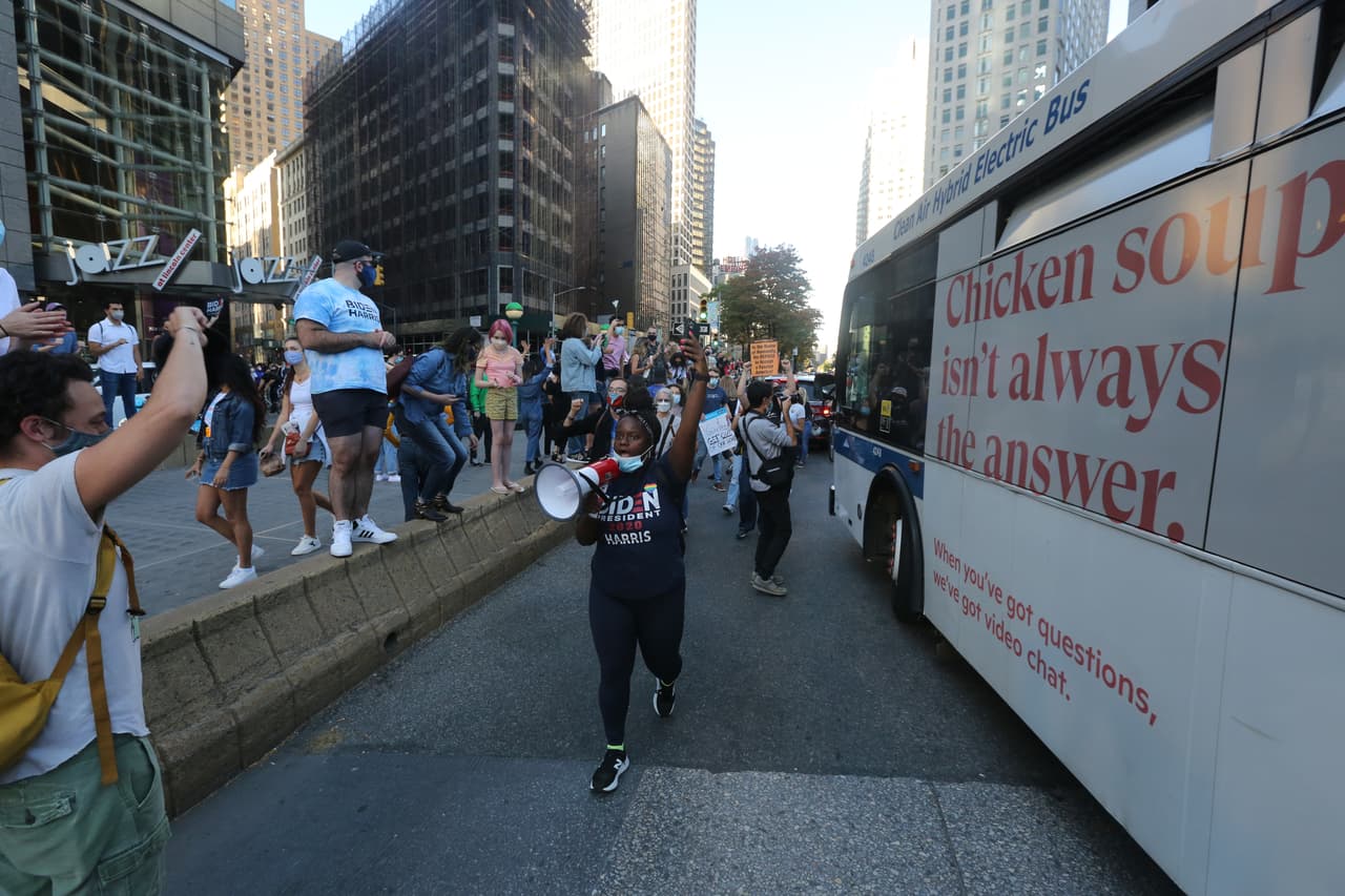Mujer con una bocina anuncia que la marcha hacia Times Square.