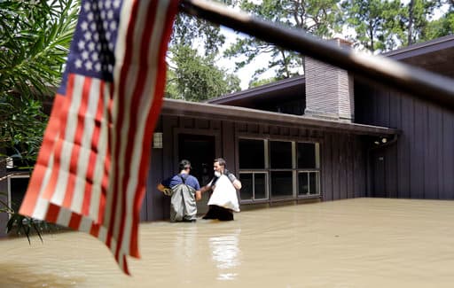 <b>El huracán Harvey causa destrozos.</b> El 25 de agosto, el podreoso ciclón tocó tierra en el estado dejando a decenas de 
<a href="https://www.univision.com/houston/kxln/noticias/huracan-harvey/en-fotos-asi-azota-el-huracan-harvey-las-costas-de-texas-fotos">miles desplazados y miles de millones en daños</a>. El gobernador Abbott pidió 61,000 millones de ayuda al gobierno federal y casi 900,000 solicitudes individuales de asistencia han sido enviadas a FEMA. En foto, dos residentes de Houston huyen tras días de lluvia que causaron 
<a href="https://www.univision.com/houston/kxln/noticias/huracan-harvey/las-calles-de-houston-se-secaron-despues-de-harvey-pero-muchos-damnificados-aun-se-sienten-bajo-el-agua">inundaciones masivas en la ciudad</a>.