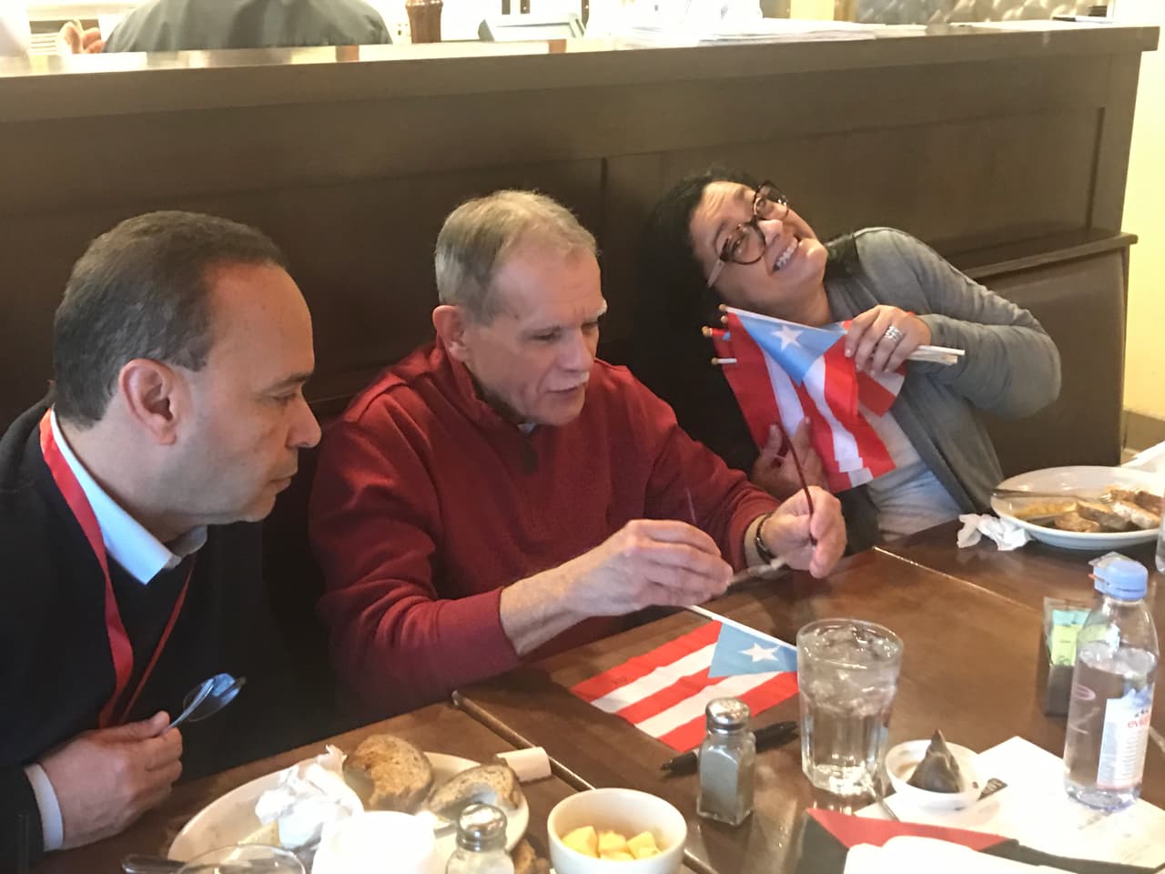 En el aeropuerto de Indianápolis, mientras desayunaban, Oscar firmó una bandera de Puerto Rico para cada uno de los que lo acompañaban en este viaje especial de regreso a la isla.