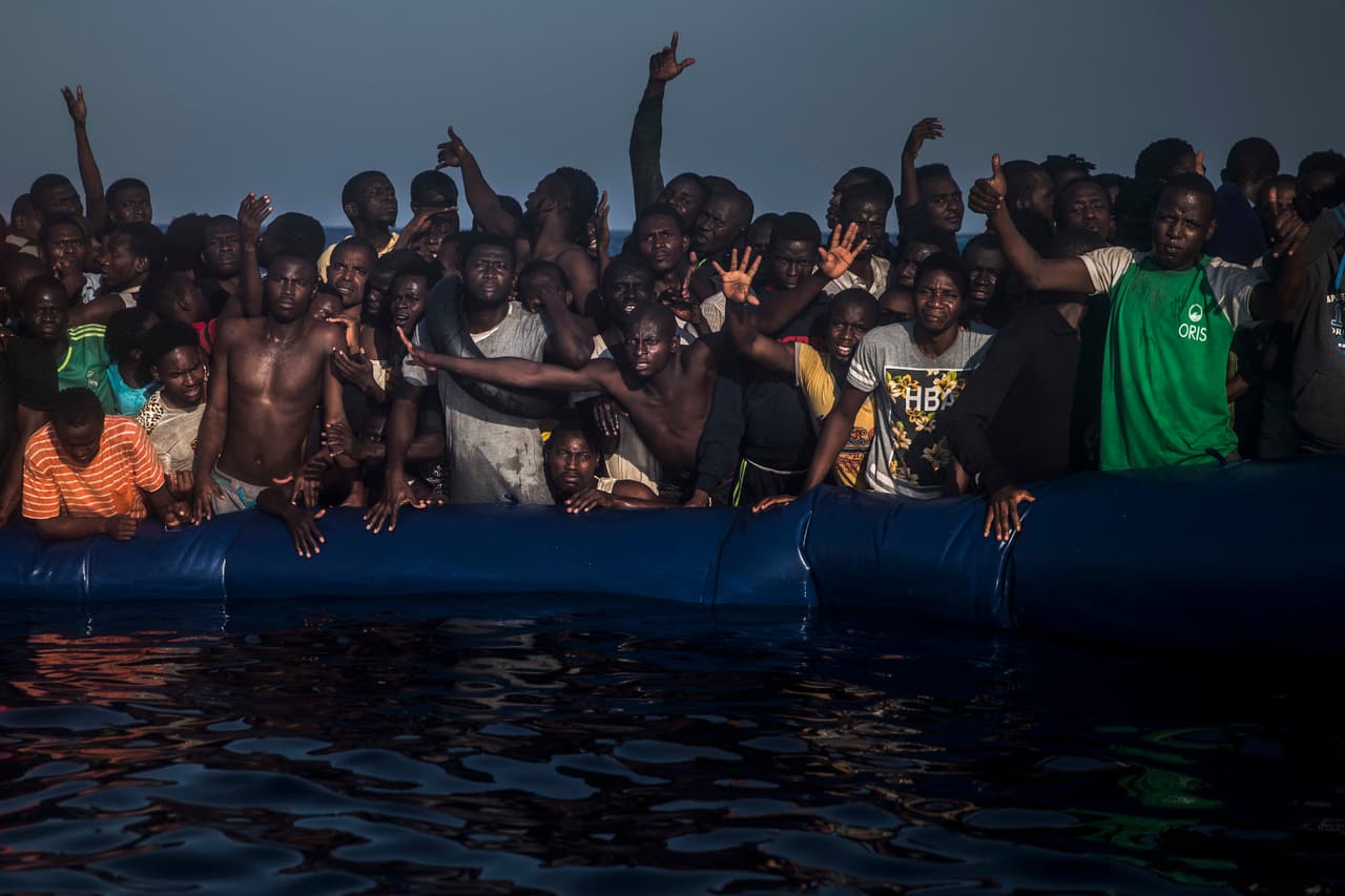 Migrantes africanos sobre un bote inflable perforado, esperan ayuda de los grupos de rescate que operan frente a las costas de Libia, el 10 de septiembre de 2016.