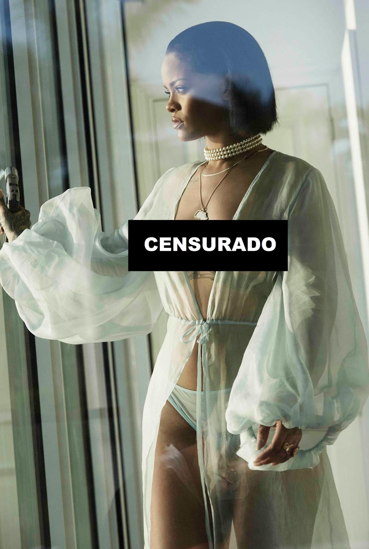 La cantante luce una bata que deja sus senos al descubierto y se pasea por una casa frente al mar pistola en mano.