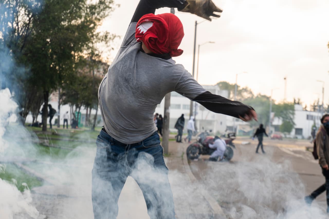 <b>Colombia, a las urnas entre el descontento y la violencia. </b>Un manifestante regresa una bomba de gas lacrimógeno a la policía durante un enfrentamiento en la Universidad Nacional de Colombia el 17 de octubre de 2019. Las calles de la capital colombiana, Bogotá, han colapsado en los últimos meses manifestaciones estudiantiles, demandas del transporte o movilizaciones sociales.