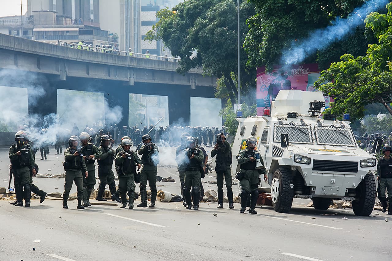 Un contingente de la Guardia Nacional Bolivariana dispara gas lacrimógeno a la multitud de manifestantes en Caracas.