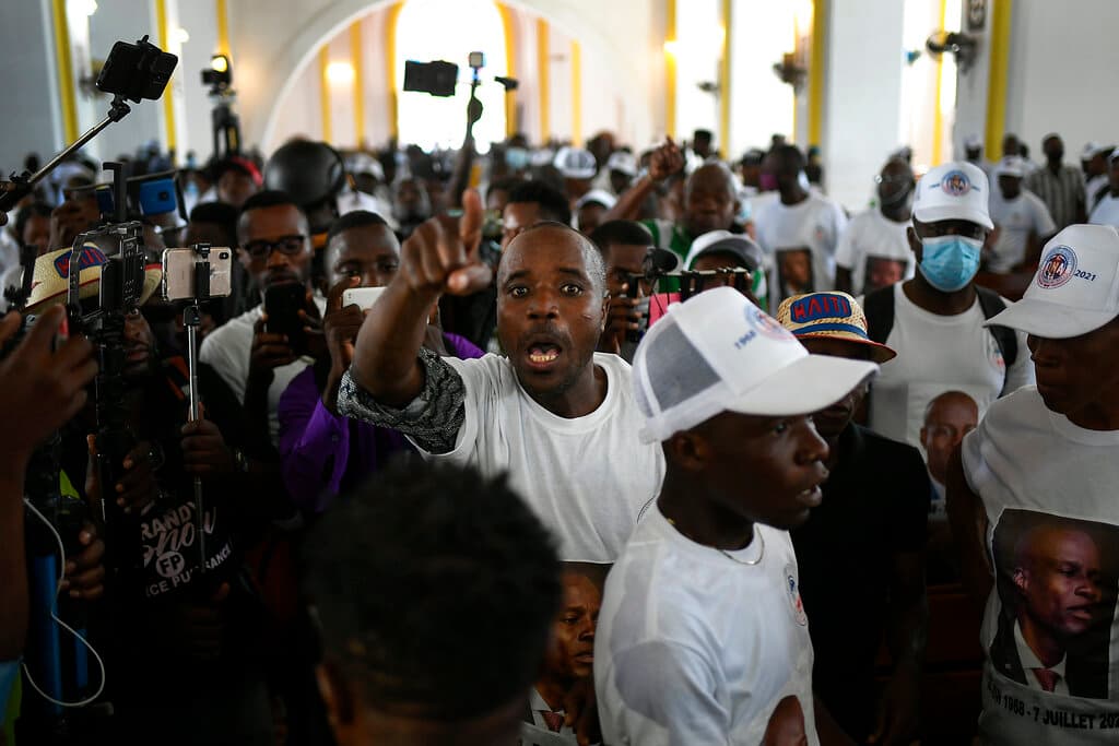 Un hombre exige que se haga justicia durante una misa el jueves 22 de julio de 2021 en honor del presidente haitiano asesinado, en la catedral de la ciudad de Cabo Haitiano. 
<a href="https://www.univision.com/noticias/america-latina/complot-contra-presidente-de-hati-reunion-santo-domingo">Según la policía, el complot para matar a Moise se organizó en una reunión en Santo Domingo el año pasado.</a>