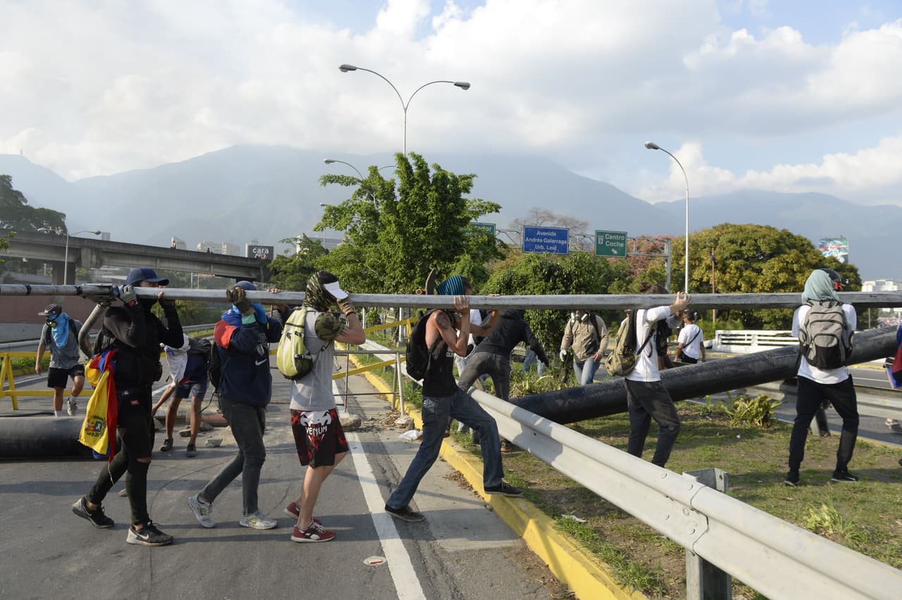 Los manifestantes tumbaros postes de luz para atravesarlos en las vías.
