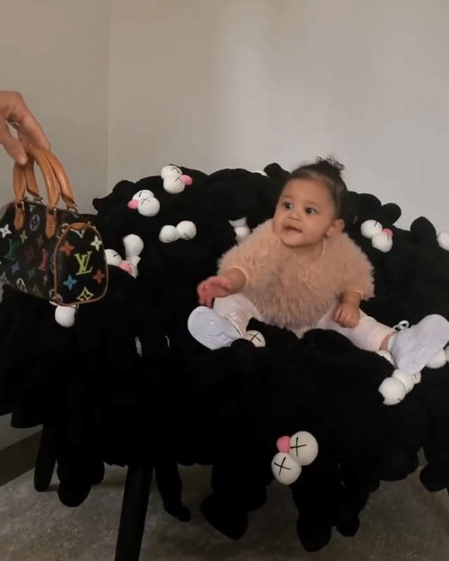 En el video se ve a la bebé de 11 meses de edad sentada sobre la silla sonriendo, al mismo tiempo que su mamá le da un bolso Louis Vuitton.