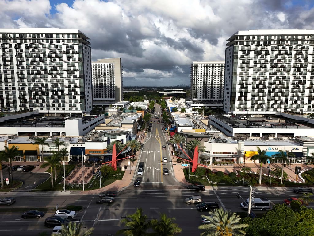 Autos pasan por la zona conocida como Downtown Doral, el sábado 5 de abril de 2025, en Doral, Florida. (AP Foto/Rebecca Blackwell)
