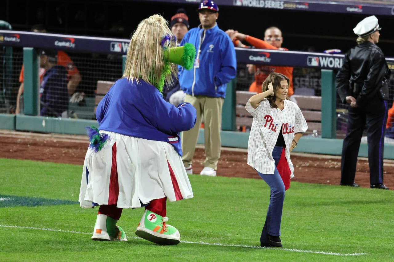 Phillie Phanatic y la actriz Cheri Oteri bailan en el campo entre entradas durante el Juego Cuatro de la Serie Mundial.