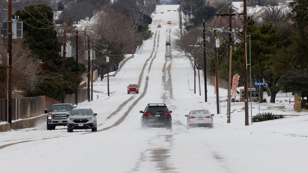Vehículos maniobran a lo largo de una calle Fuller-Wiser cubierta de nieve en Euless, Texas, el jueves 18 de febrero de 2021.