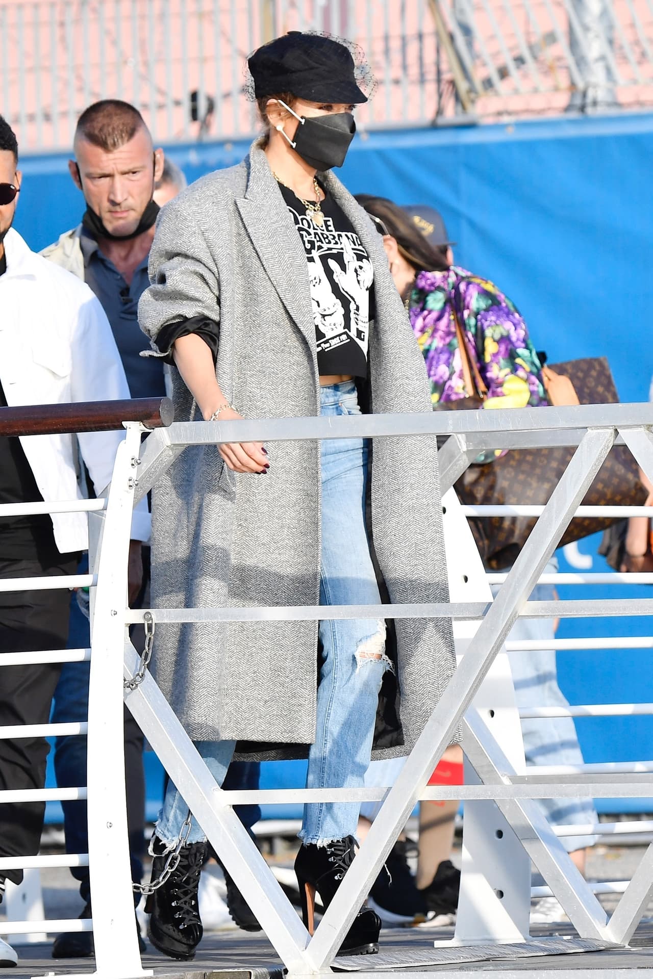 Se acompañó de un abrigo gris texturizado sobre la parte superior y 
<b><a href="https://www.univision.com/famosos/jlo-cumple-51-anos-estos-son-los-looks-que-la-han-encumbrado-como-un-icono-de-la-moda-fotos" target="_blank">altísimos tacones con cordones. </a></b>
<br>