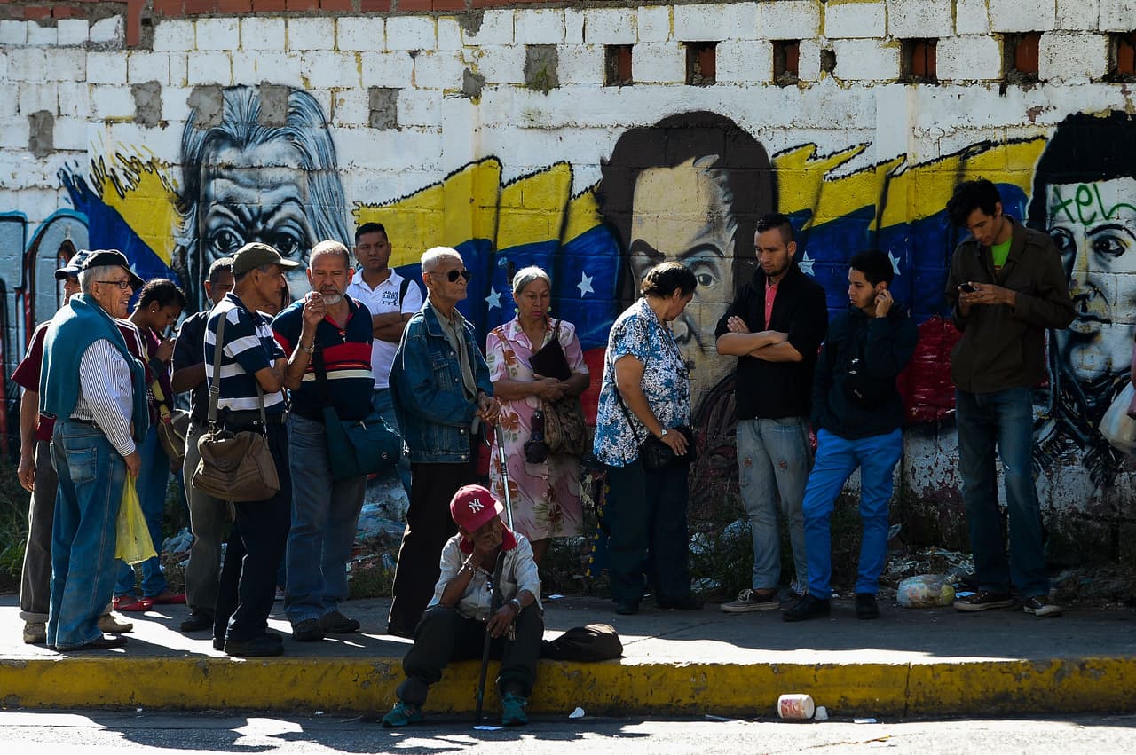 Cientos de caraqueños hacen filas en los alrededores del Banco Central de Venezuela para canjear los viejos billetes.