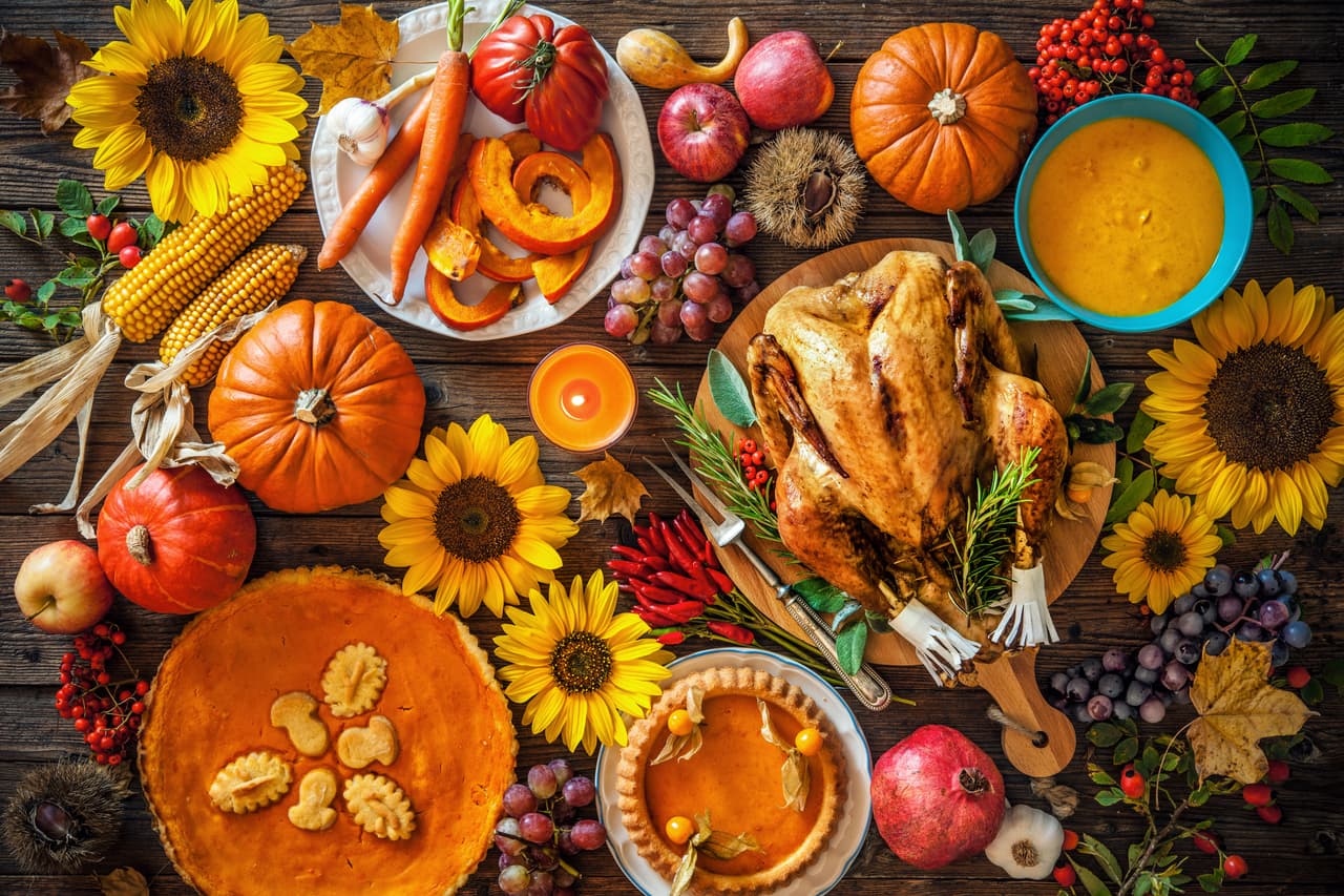 Thanksgiving dinner. Roasted turkey with pumpkins and sunflowers on wooden table