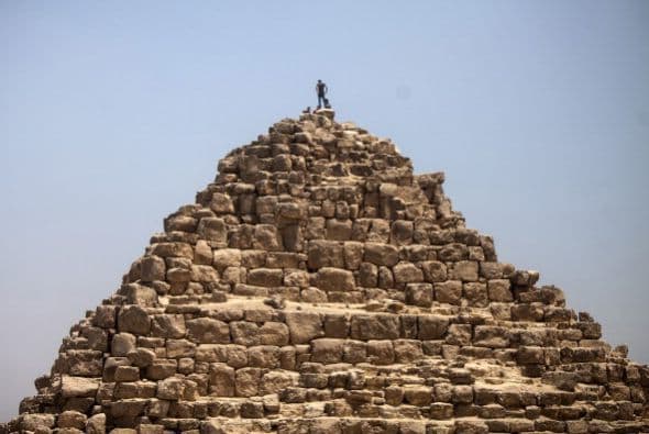 Así de pequeño se ve este hombre en la cima de una de las pirámides de Giza, al sur del Cairo.