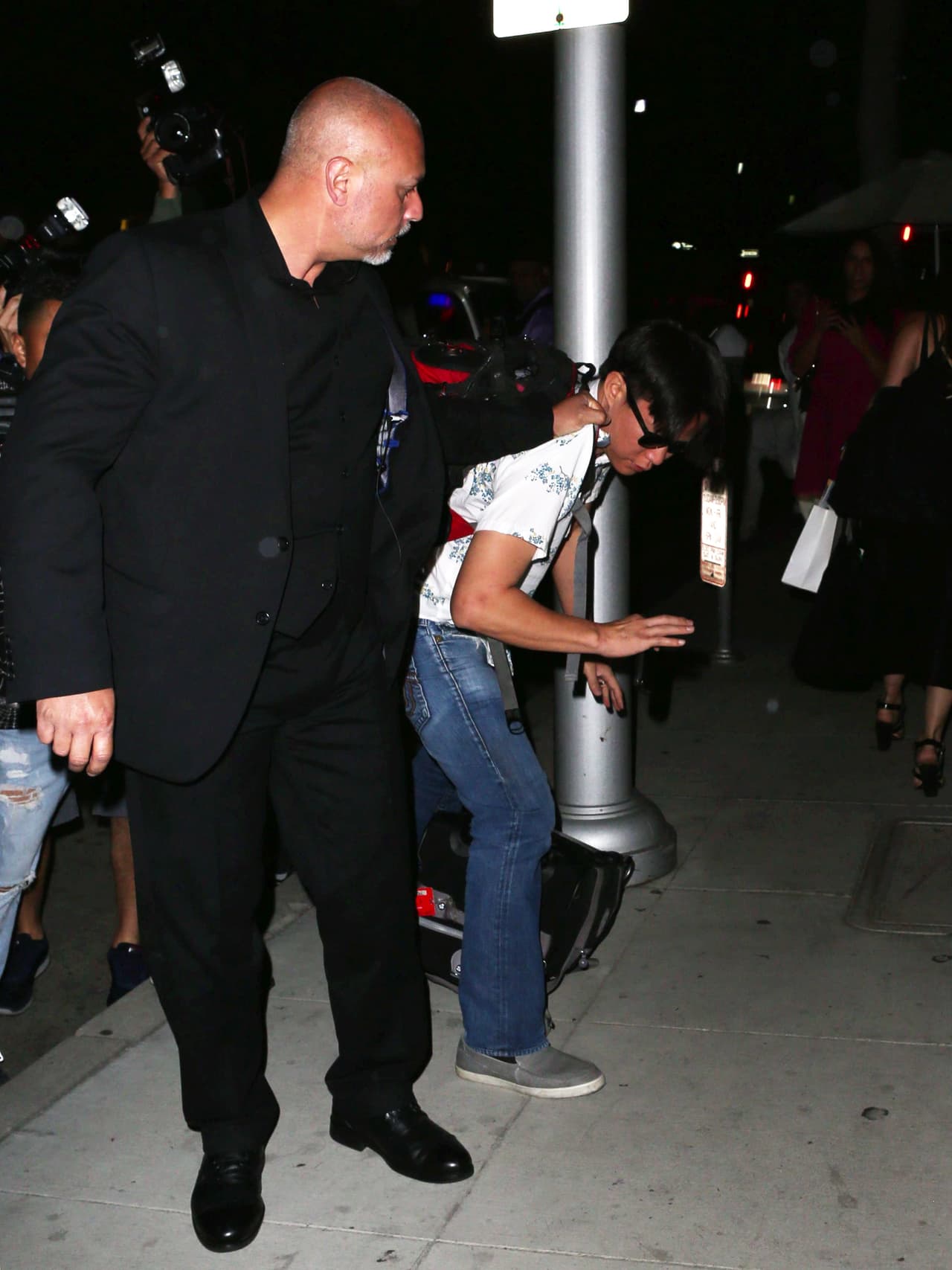 Con gafas de sol en la noche y rasgos asiáticos, el hombre fue detenido por los guardaespaldas de Kim Kardashian.