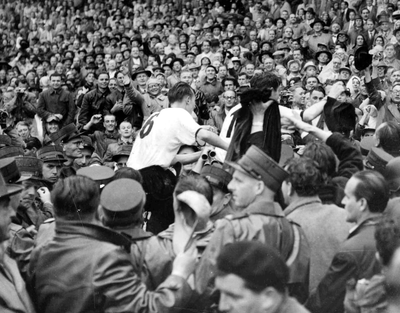 El capitán alemán Fritz Walter, parcialmente oculto en el centro derecha, y el mediocampista derecho Horst Eckel, número 9, son llevados en hombros por la multitud tras ganar la Copa Mundial de Fútbol en Basilea, Suiza, el 4 de julio de 1954.