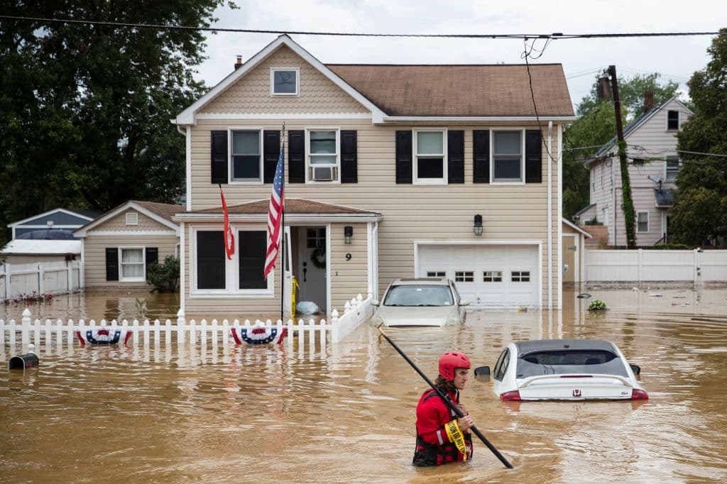 Un bombero camina por una zona totalmente inundada en Helmetta, Nueva Jersey, tras el paso de la tormenta Henri.
