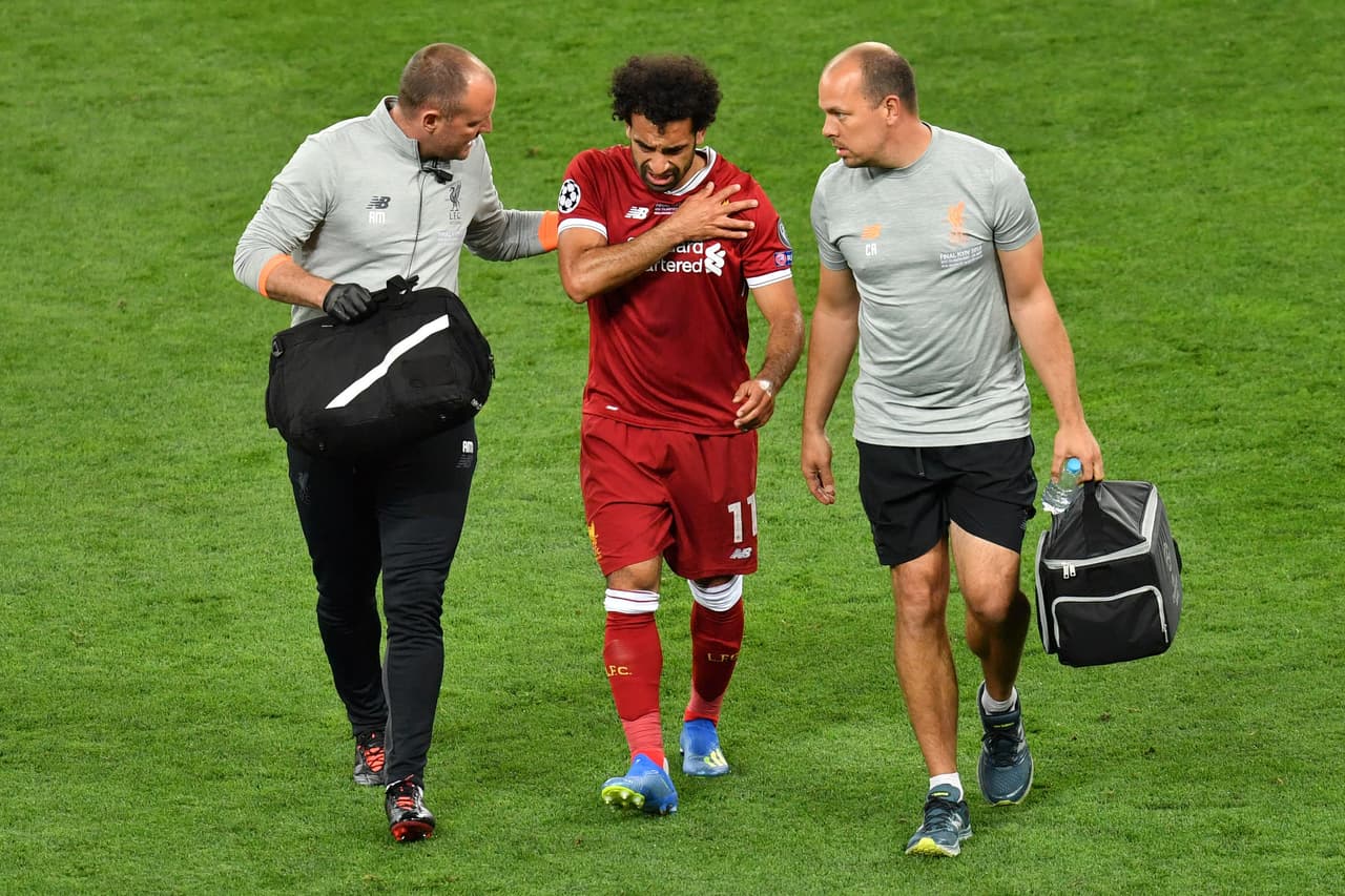 TOPSHOT - Liverpool's Egyptian forward Mohamed Salah (C) gets medical assistance as he leaves the pitch following injury during the UEFA Champions League final football match between Liverpool and Real Madrid at the Olympic Stadium in Kiev, Ukraine on May 26, 2018. (Photo by Sergei SUPINSKY / AFP) (Photo credit should read SERGEI SUPINSKY/AFP/Getty Images)