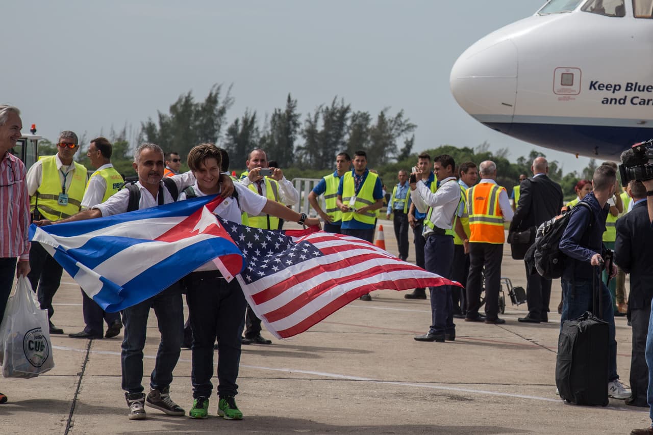 Two passengers carried a US and a Cuban flag as they disembarked in Santa Clara.